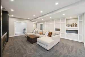 Carpeted living room featuring recessed lighting and built in shelves