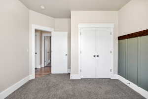 Unfurnished bedroom with carpet and a closet