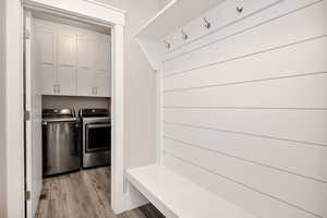 Mudroom featuring light wood-style flooring and washer and dryer