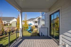 Wooden deck featuring a playground and a lawn