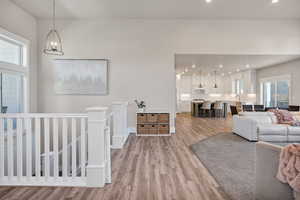 Living room with light wood-style flooring, recessed lighting, and a chandelier