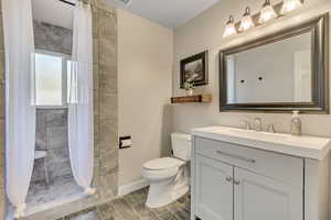 Bathroom with a shower stall, vanity, and wood tiled floors