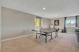 Game room with light colored carpet, plenty of natural light, and recessed lighting