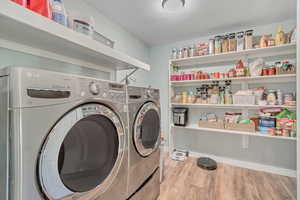 Laundry room with light wood-style flooring and separate washer and dryer