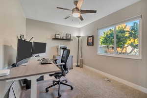 Office area featuring light carpet and ceiling fan