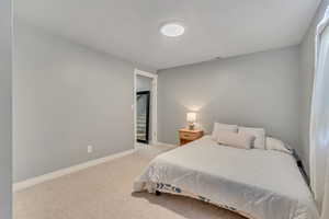 Bedroom featuring light colored carpet and baseboards