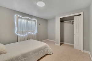 Bedroom featuring light colored carpet and a closet
