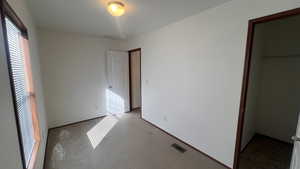 Unfurnished bedroom featuring carpet flooring and a spacious closet