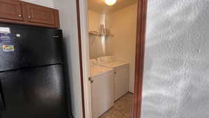 Laundry room with separate washer and dryer and light tile patterned floors