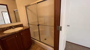 Bathroom with a stall shower, vanity, and light tile patterned floors