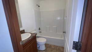 Full bathroom with light tile patterned floors, vanity, and shower / bathtub combination