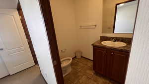 Half bath featuring vanity and dark tile patterned floors