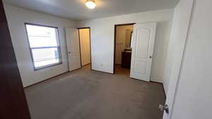 Unfurnished bedroom featuring carpet and ensuite bathroom