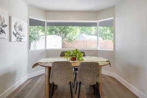 Dining space with a textured wall, healthy amount of natural light, and wood finished floors