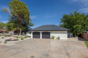 View of property exterior featuring concrete driveway, brick siding, and a shingled roof