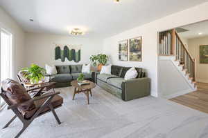 Carpeted living area featuring stairway and wood finished floors