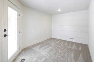 Unfurnished room featuring light carpet