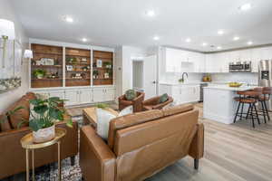 Living area with light wood-style flooring and recessed lighting