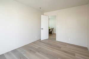 Unfurnished room with light wood-type flooring and baseboards