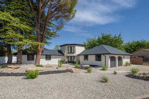 View of front of property featuring brick siding, concrete driveway, a garage, and a shingled roof