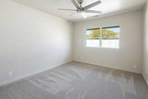 Empty room with ornamental molding, light colored carpet, a ceiling fan, and a textured ceiling