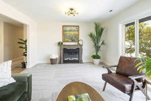 Living room featuring a glass covered fireplace and carpet