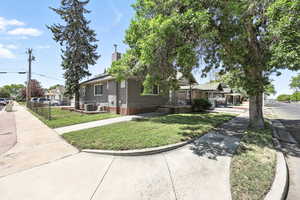View of front of home with a front yard, brick siding, and a chimney