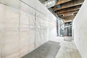 Unfinished below grade area featuring water heater and heating unit