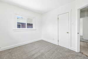 Unfurnished bedroom with carpet flooring and baseboards