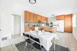 Dining space featuring light tile patterned flooring and baseboards