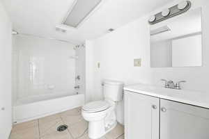 Full bathroom with light tile patterned floors, vanity, and washtub / shower combination