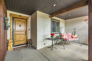 Property entrance with stucco siding and covered porch