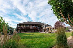 Rear view of property with stairway, a patio area, and a lawn