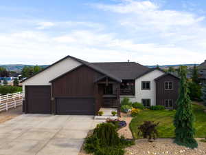 View of front of home featuring driveway, an attached garage, stucco siding, and stairs