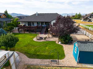 Back of house with a patio area, an outbuilding, an outdoor fire pit, a deck with mountain view, and stairs