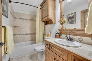 Bathroom featuring vanity and shower / bath combination with curtain