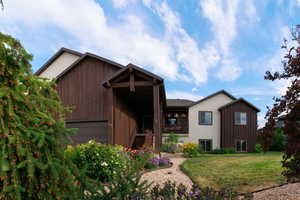 View of front of property featuring a front lawn, stairs, and a garage