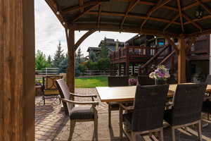 View of patio featuring outdoor dining area, stairway, and a gazebo