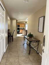 Hallway with light tile patterned floors and a textured ceiling