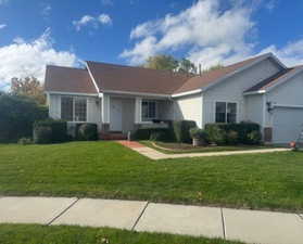 Ranch-style house with an attached garage and a front lawn