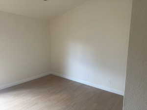 Empty room featuring wood finished floors and baseboards