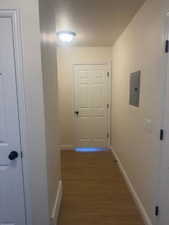 Hall with dark wood-style flooring and electric panel