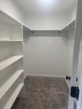 Walk in closet with dark carpet