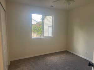 Spare room featuring carpet floors and a ceiling fan