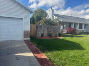 View of side of property with a garage, driveway, and an outbuilding