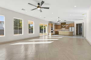 Unfurnished living room with a chandelier, recessed lighting, and ceiling fan