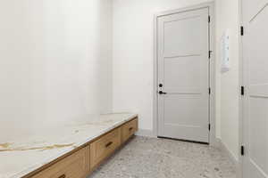 Mudroom featuring baseboards and electric panel