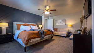 Carpeted bedroom with a decorative wall and ceiling fan