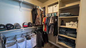 Walk in closet with dark carpet