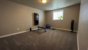Exercise area featuring carpet flooring and a textured ceiling